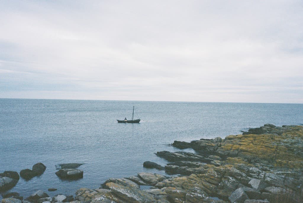 Small boat near rocky shore